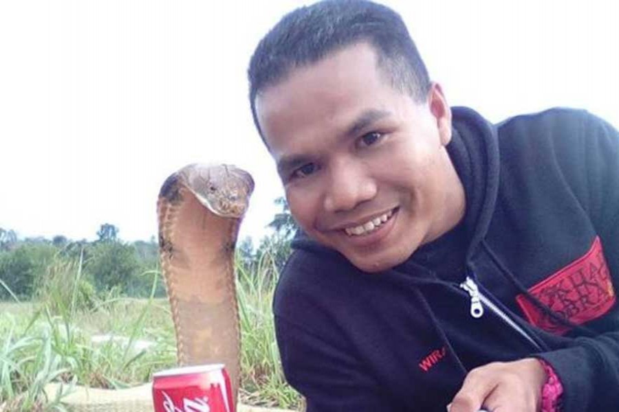 Abu Zarin Hussin takes a selfie with one of his snakes