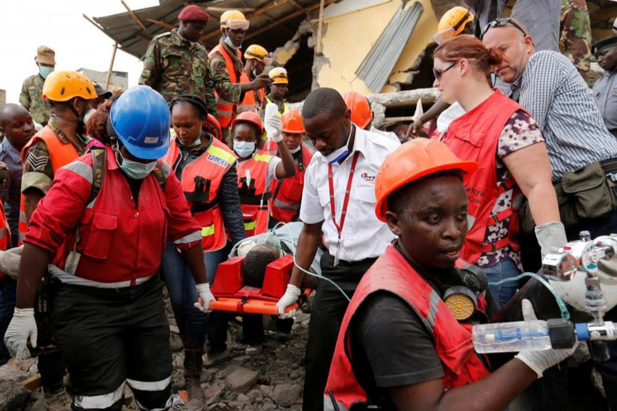 Kenya Red Cross rescuers evacuate a woman from the rubble of a six-storey building that collapsed after days of heavy rain killing 49 people in total, in Nairobi, Kenya May 5, 2016. Reuters/File Photo
