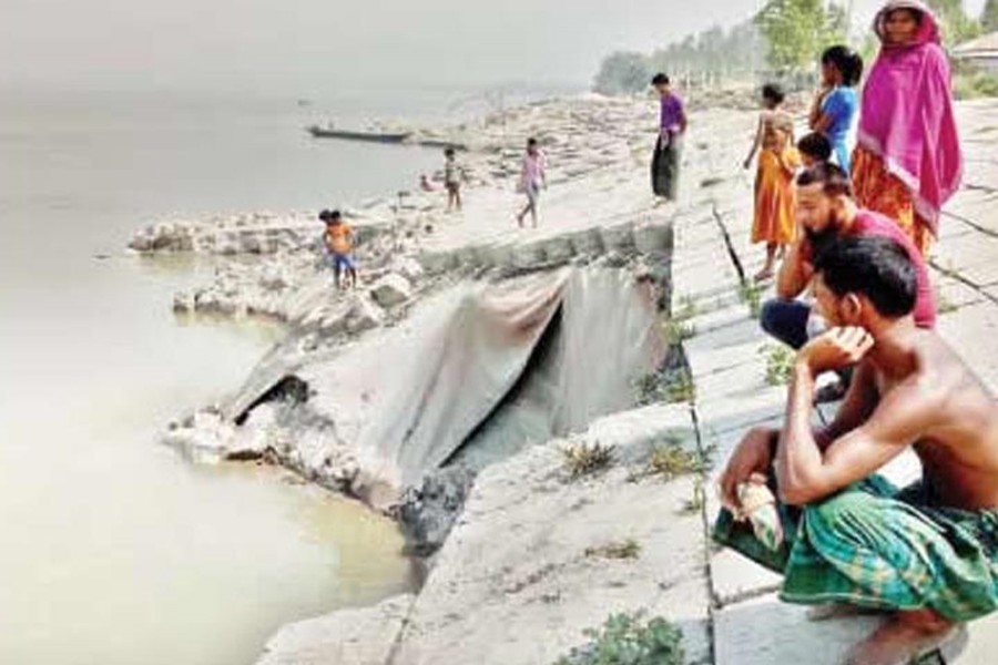 Anxious inhabitants of Khas Kaulia area under Chouhali upazila of Sirajganj sitting beside the collapsed embankment. The snap was clicked on Monday 	— FE photo