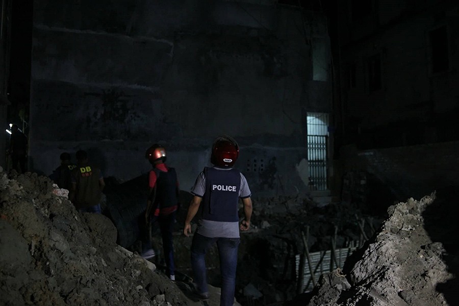Lawmen search a building at Middle Pirerbagh in Dhaka's Mirpur for suspected criminals after a gunfight left one DB inspector dead