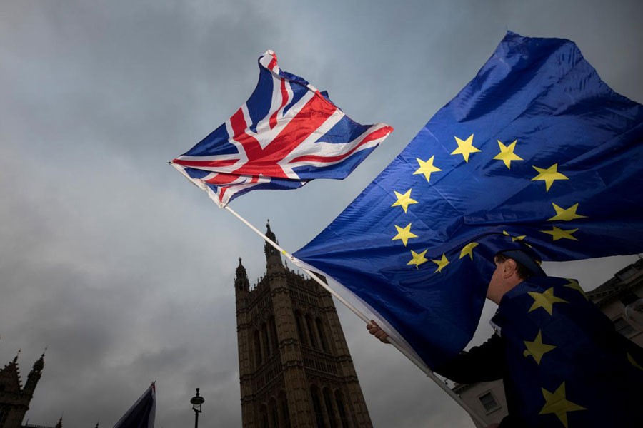 An Anti-Brexit protestor waves EU and Union flags outside the Houses of Parliament in London, Britain December 5, 2017. Reuters.