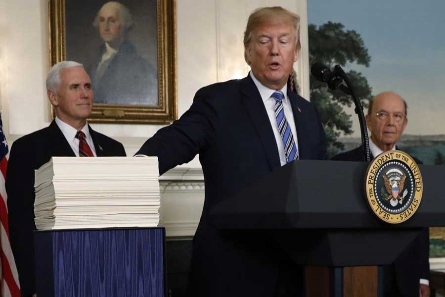 US President Donald Trump points to Congress' $1.3 trillion spending bill during a signing ceremony in the Diplomatic Room of the White House in Washington, March 23, 2018. Reuters