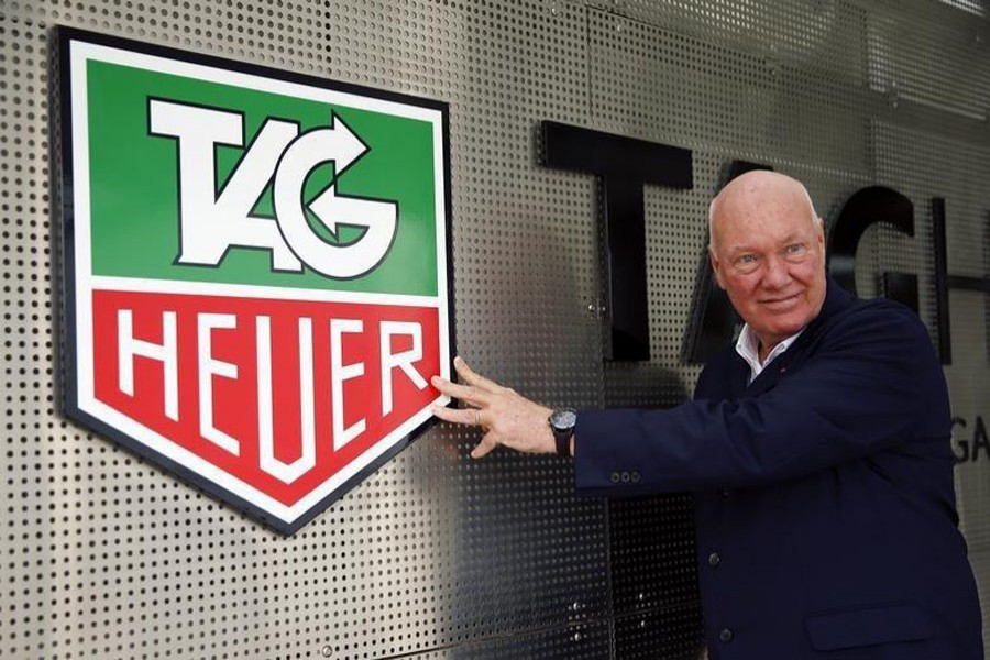 Tag Heuer boss Jean-Claude Biver poses in front of the company's logo before a news conference in western Swiss town La Chaux-de-Fonds December 16, 2014. Reuters/File