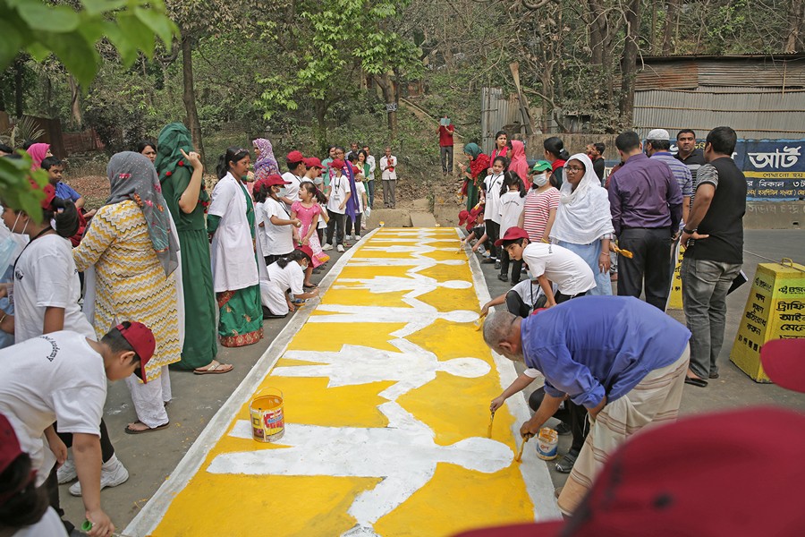 Students of Frobel Academy painting a children-friendly zebra crossing on a Panchlaish road on Monday
