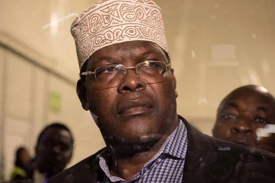 Miguna Miguna, a lawyer of dual Kenyan and Canadian citizenship, is seen through the glass door at the Jomo Kenyatta airport after he was detained by police in Nairobi, Kenya March 26, 2018, during an attempt to force him onto a plane to Canada. Reuters.
