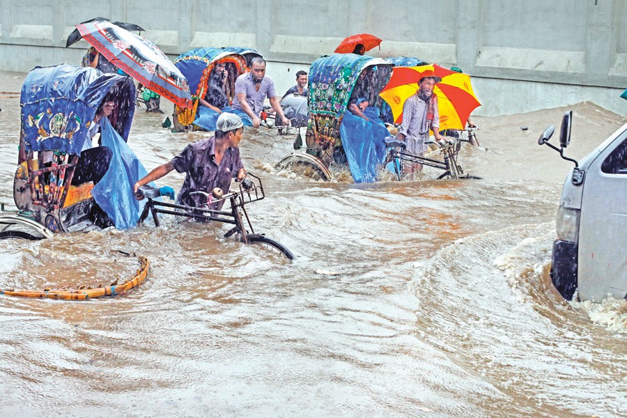 Rickshaws moving through a waterlogged road in the Motijheel area of the city during the last rainy season 	— FE file photo