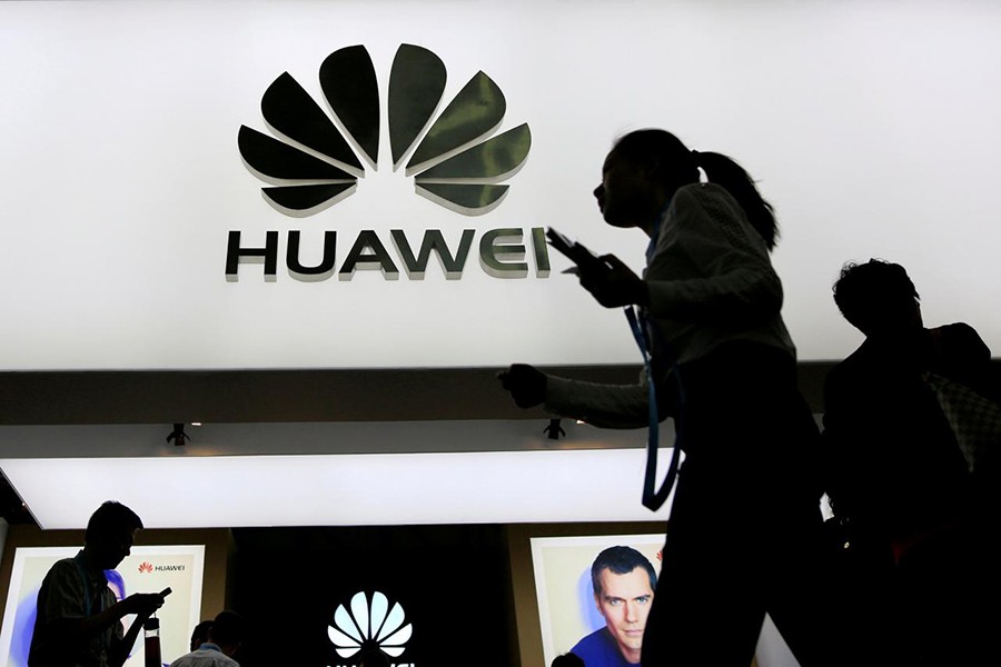 People walk past a sign board of Huawei at CES (Consumer Electronics Show) Asia 2016 in Shanghai, China on May 12, 2016 - Reuters file photo