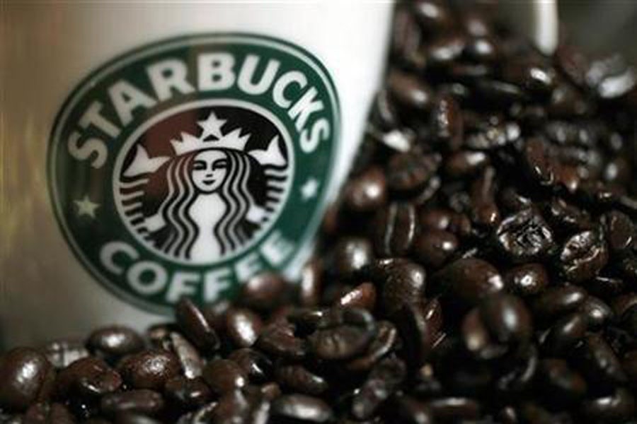 A mug bearing a Starbucks logo is pictured next to coffee beans during a news conference in Tokyo April 13, 2010. Reuters/File