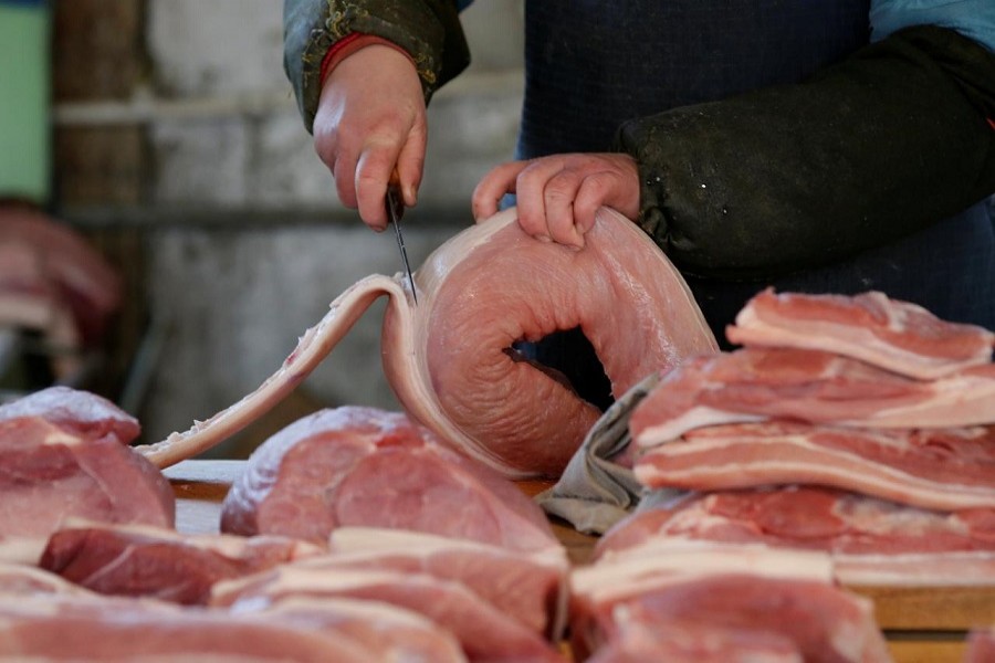A butcher cuts a piece of pork at a market in Beijing, China, March 25, 2016. Reuters/File Photo