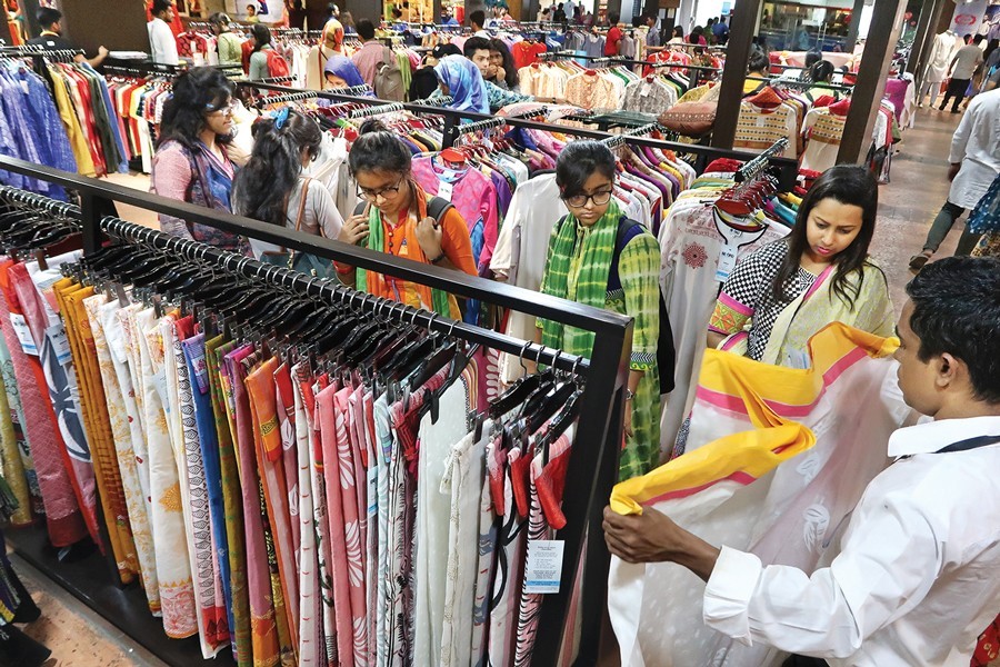 Shoppers busy selecting sarees of their choice at a shop at Bashundhara City shopping mall on Friday for Pahela Baishakh, the first day of Bangla New Year — FE photo