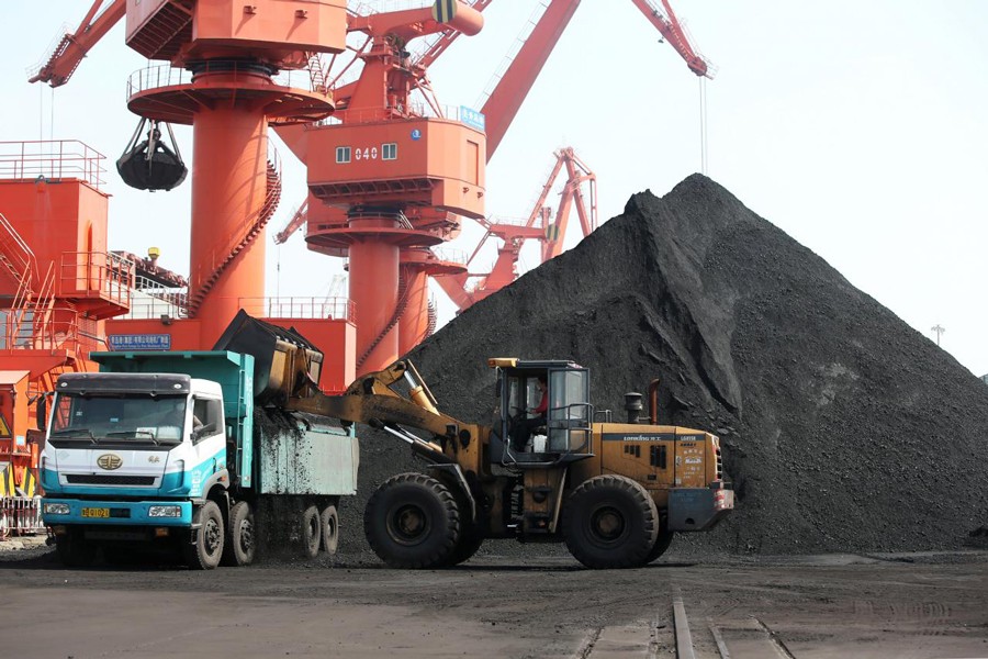 A worker operating a loader to transport coal at a port in Qingdao, Shandong province, China recently 	 — Reuters