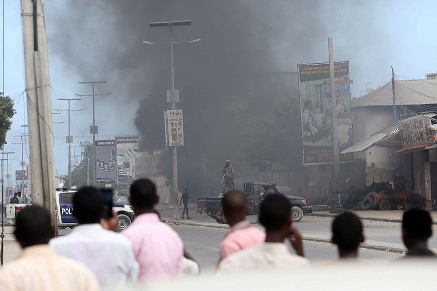 Civilians look on as smoke billows from the scene of an explosion at a security checkpoint in the Hodan district of Mogadishu - Reuters file photo used only for representation