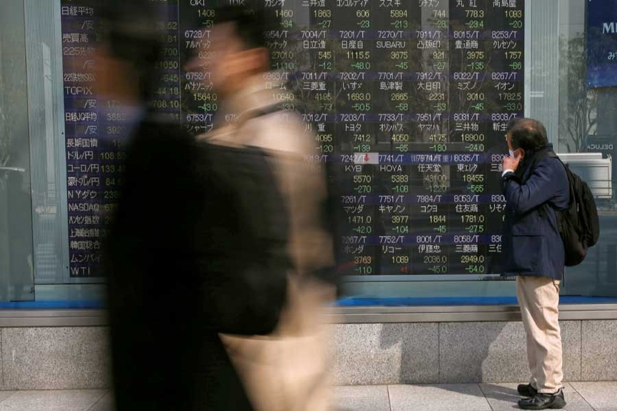 A man looks at an electronic stock quotation board outside a brokerage in Tokyo, Japan February 9, 2018. Reuters/Files