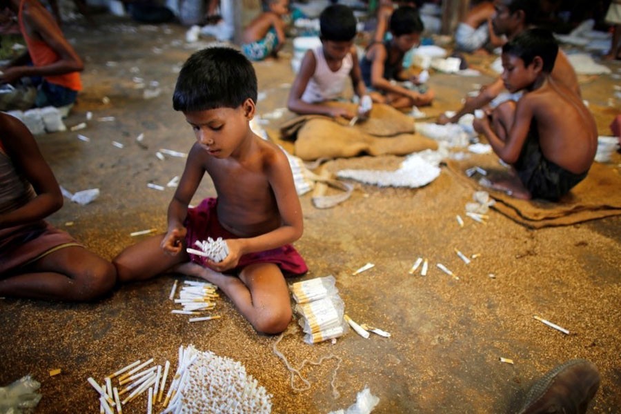 Children fill up empty cigarettes manually with locally grown tobacco in a small bidi (cigarette) factory at Haragach in Rangpur district, Bangladesh. –Reuters