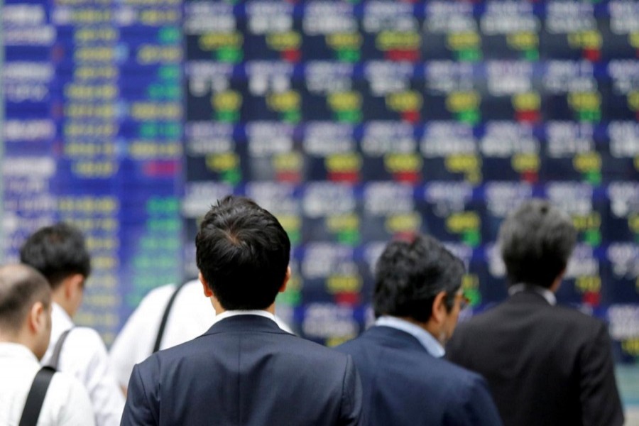 A man walks past an electronic stock quotation board outside a brokerage in Tokyo, Japan, September 22, 2017. Reuters/Files