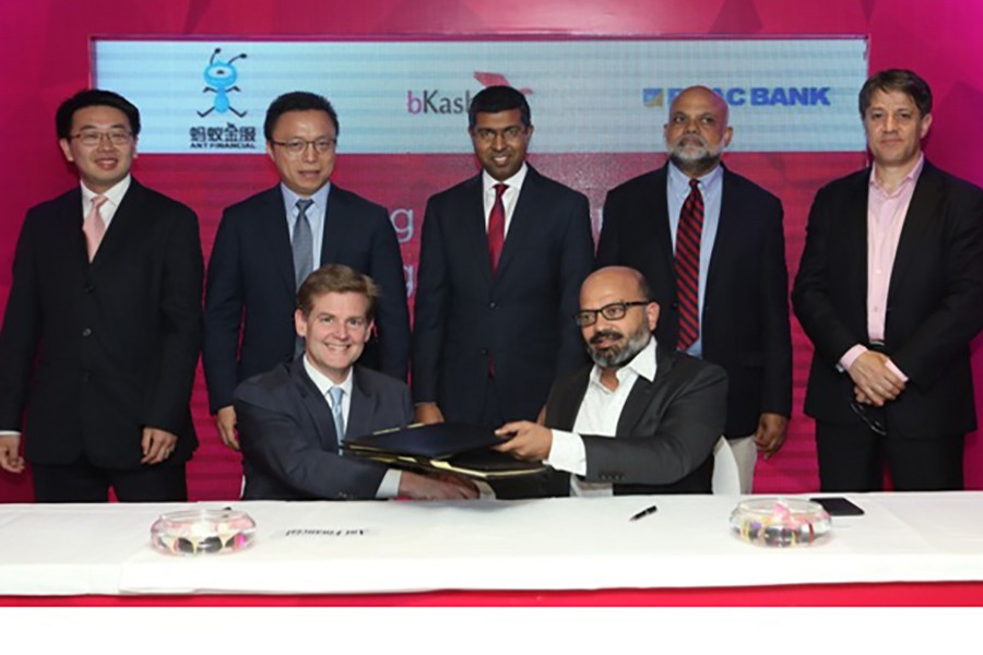 Kamal Quadir, Chief Executive Officer of bKash Ltd, and Douglas Feagin, Senior Vice President of Ant Financial, exchanging documents after signing an agreement on strategic partnership to promote financial inclusion of the unbanked in Bangladesh — Collected