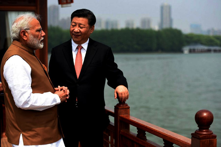 India's Prime Minister Narendra Modi speaking with Chinese President Xi Jinping as they take a boat ride on the East Lake in Wuhan in China on Saturday. -Reuters Photo
