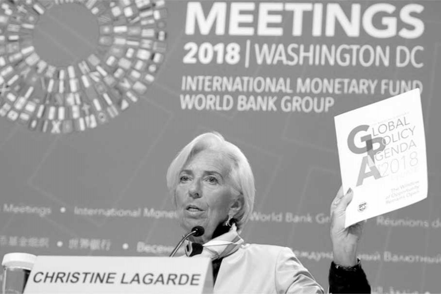 IMF Managing Director Christine Lagarde holds up a copy of the Global Policy Agenda as she holds a press conference during the 2018 Spring Meetings of the International Monetary Fund and World Bank Group at IMF Headquarters in Washington.