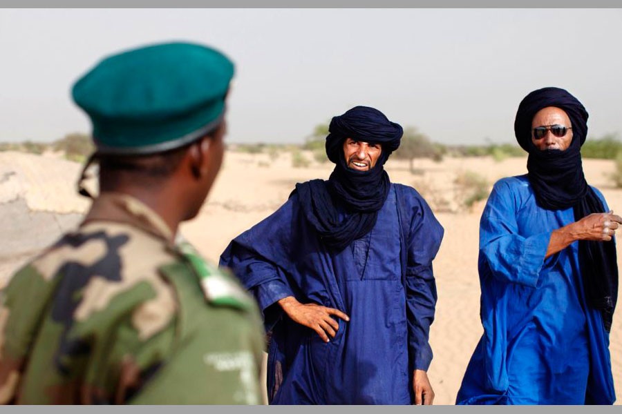 A Malian soldier speaks with Tuareg men in the village of Tashek, outside Timbuktu, July 27, 2013. Reuters file photo.
