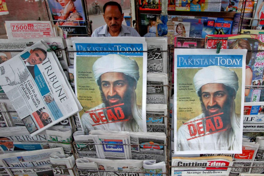 A roadside vendor sells newspapers with headlines about the death of al Qaeda leader Osama bin Laden, in Lahore May 3, 2011. Reuters file photo.
