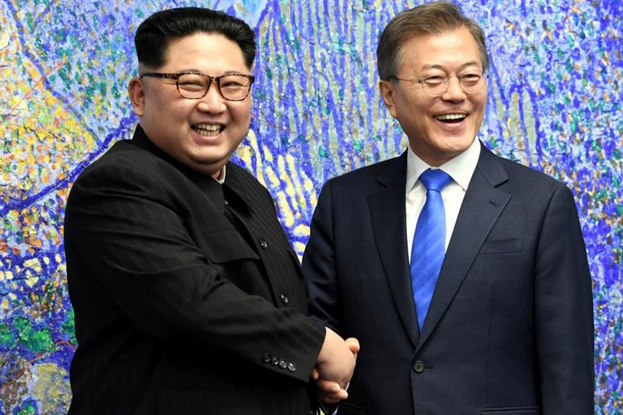South Korean President Moon Jae-in (R) shakes hands with North Korean leader Kim Jong-un during their meeting at the Peace House on Friday - Reuters