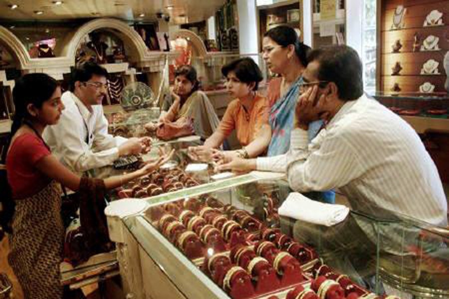 Customers looking at gold bangles in a jewellery shop in Mumbai 	— Reuters