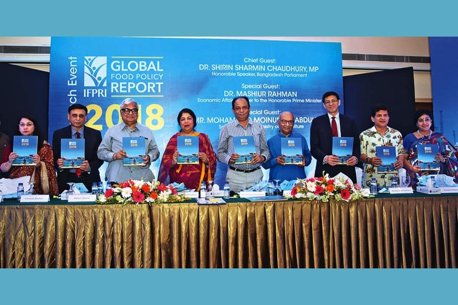 Jatiya Sangsad Speaker Shirin Sharmin Chaudhury and other dignitaries holding the copies of 'Global Food Policy Report 2018' published by the International Food Policy Research Institute at its launching ceremony at a city hotel on Thursday — FE Photo