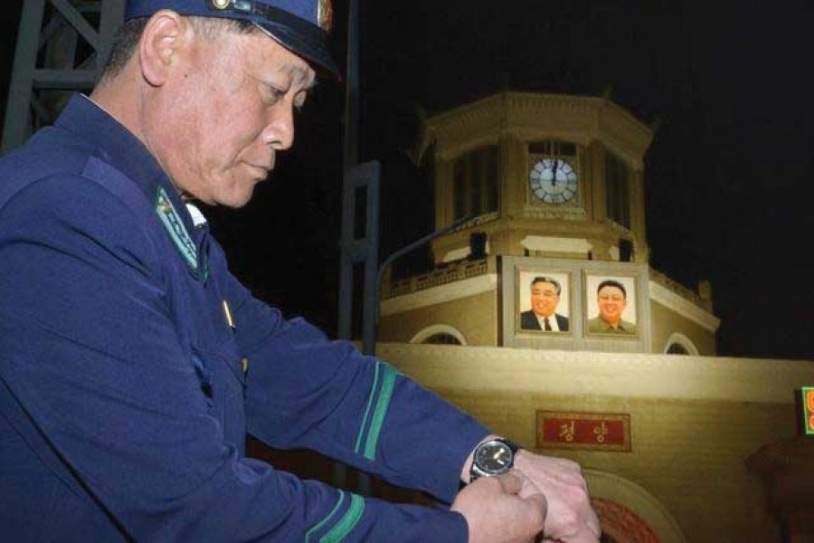 An unidentified uniformed man adjusts his wristwatch in front of a clock of the Pyongyang Station in Pyongyang, North Korea, early Saturday, May 5, 2018. North Korea readjusted its time zone to match South Korea's on Saturday and described the change as an early step toward making the longtime rivals "become one" following a landmark summit. The portraits seen in the background are the late leaders, Kim Il Sung, left, and Kim Jong Il.   —Photo: AP