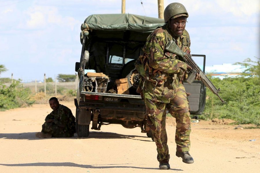 A Kenya Defence Force soldier runs for cover near the perimeter wall where attackers are holding up at a campus in Garissa April 2, 2015. Reuters.