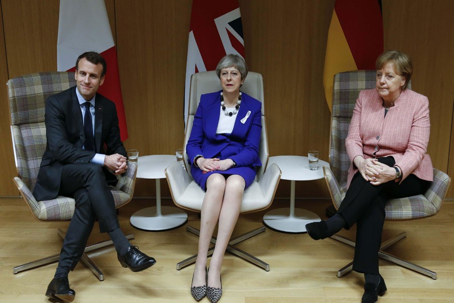 Britain’s Prime Minister Theresa May is flanked by French President Emmanuel Macron and German Chancellor Angela Merkel before their trilateral meeting at the European Union leaders summit in Brussels, Belgium, March 22, 2018. Reuters.