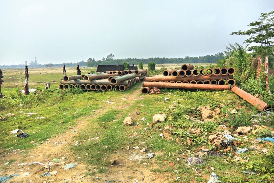Electricity poles, brought for installation at the Sreehatta Economic Zone (EZ) in Moulvibazar, lying abandoned following legal complications over the EZ — FE Photo
