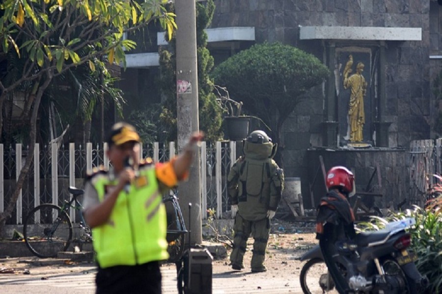 A member of the police bomb squad unit examines the site of an explosion outside the Immaculate Santa Maria Catholic Church, in Surabaya, East Java, Indonesia May 13, 2018 in this photo taken by Antara Foto. Reuters