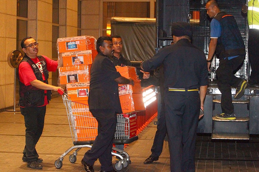 Police prepare to load confiscated items into a truck in Kuala Lumpur, Malaysia on Friday after a raid on a condominium belonging to former Prime Minister Najib Razak - AP photo