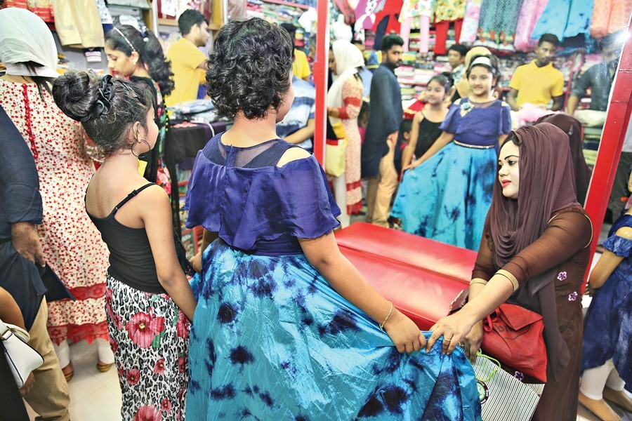 Customers making their choice of dresses at a shopping complex at Shantinagar in the capital on Friday, the weekly holiday, ahead of Eid — FE Photo