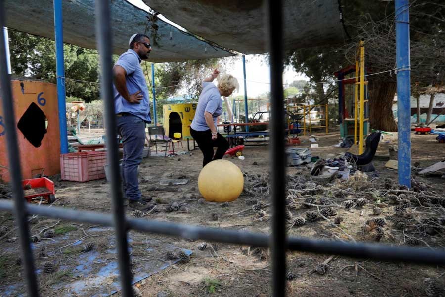 People stand in a kindergarten yard damaged by mortar shells fired from the Gaza Strip that landed near it, in a Kibbutz on the Israeli side of the Israeli-Gaza border, May 29, 2018. Reuters