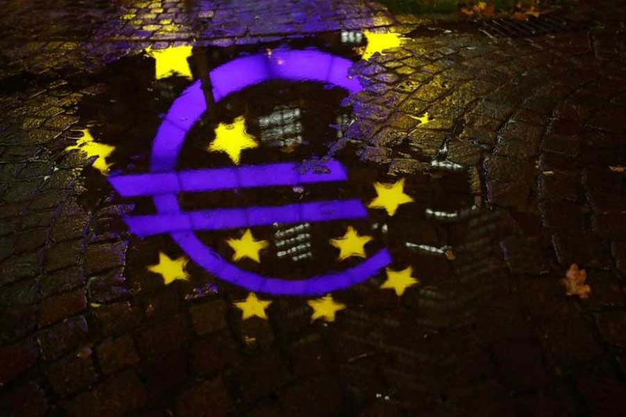 The euro sign in front of the former headquarters of the European Central Bank (ECB) is reflected in a puddle during heavy rain in Frankfurt, Germany, November 20, 2017. Reuters/Files