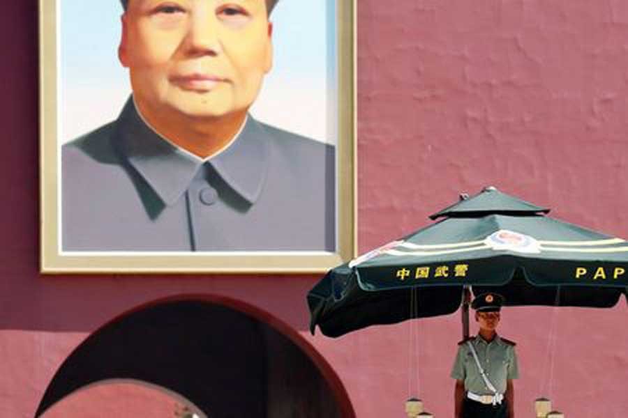 A paramilitary policeman keeps watch underneath the portrait of former Chinese Chairman Mao Zedong in Beijing's Tiananmen Square, China, June 4, 2018. Reuters/Files