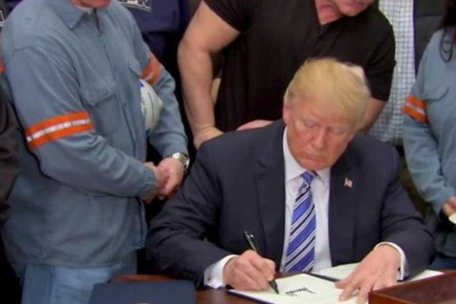 US President Donald Trump signs a presidential proclamation placing tariffs on steel and aluminum imports while surrounded by workers from the steel and aluminum industries at the White House in Washington on March 08, 2018. 	— Photo: Reuters