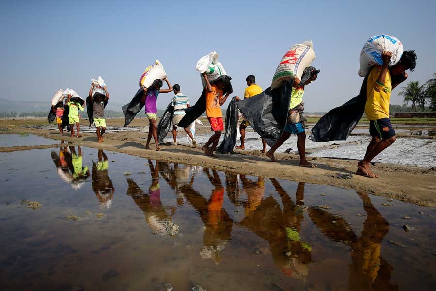 Rohingya refugee workers carrying bags of salt this month in a processing yard in Cox's Bazar. Reuters/Files