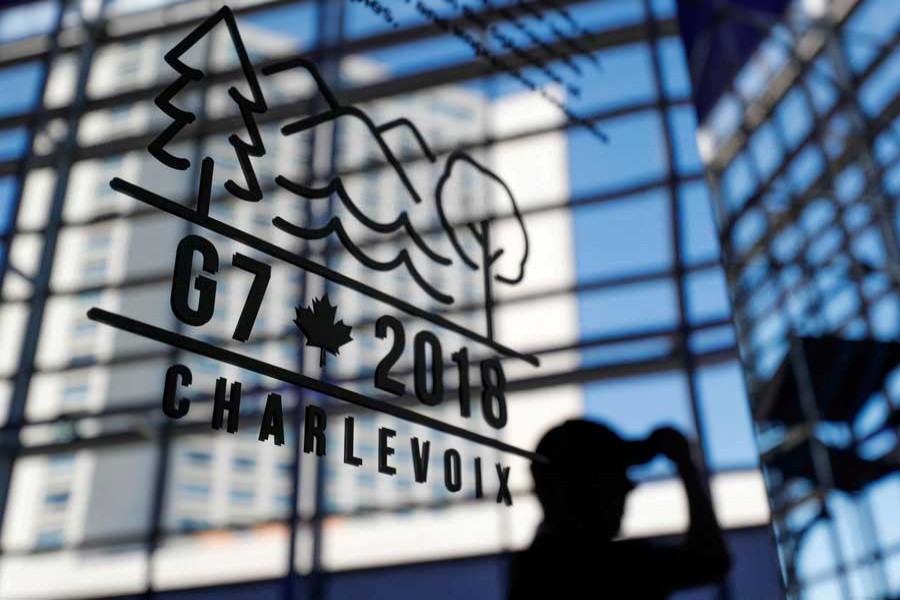 A man walks past the Charlevoix G7 logo at the main press center ahead of the G7 Summit in Quebec, Canada, June 6, 2018. Reuters