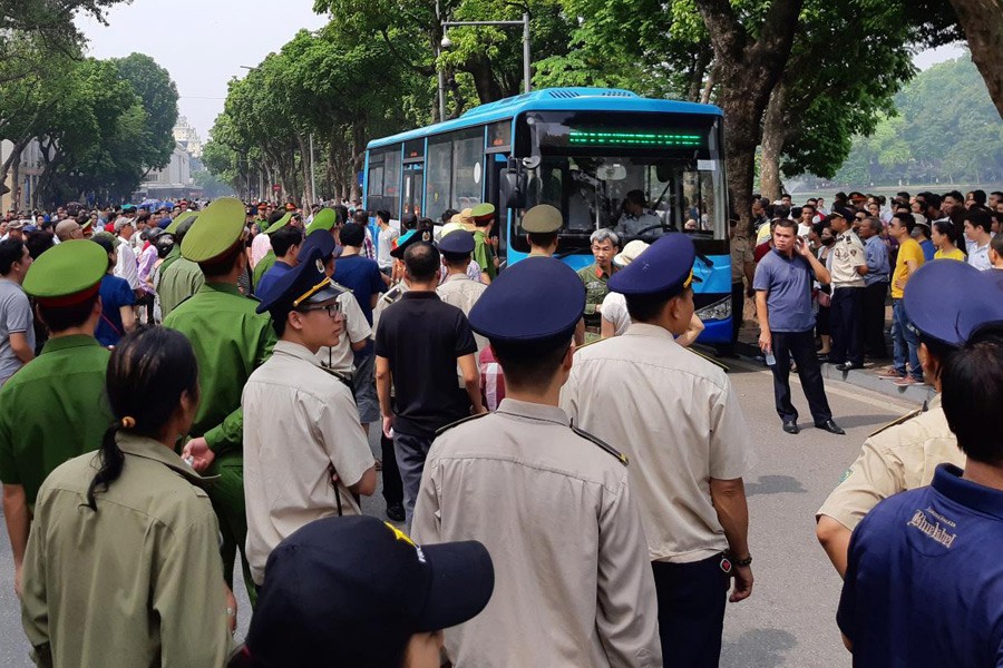 Police stand around a bus after they detained protesters during a demonstration against a draft law on the Special Economic Zone in Hanoi, Vietnam June 10, 2018. Reuters.
