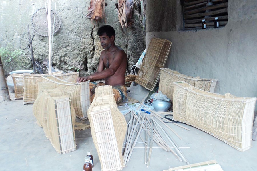 A craftsman making traditional bamboo-made fishing gear in Kahaloo upazila of Bogura on Sunday   	— FE Photo