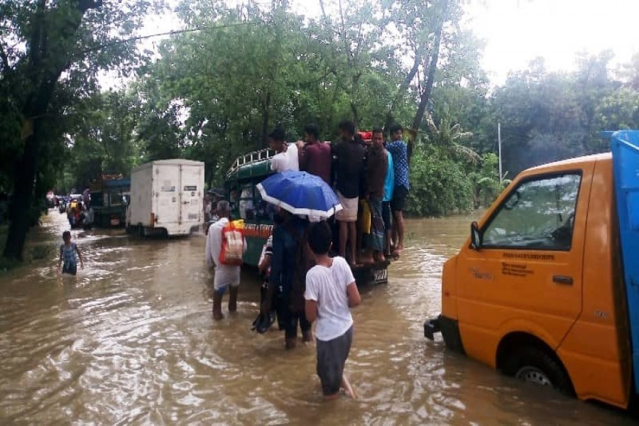 People wading through knee-deep water on a road in Raoza of Chattogram  on Tuesday    -Photo: UNB