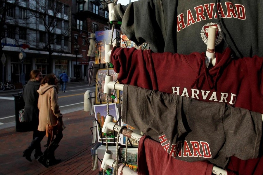 People walk past Harvard University t-shirts for sale in Harvard Square in Cambridge, Massachusetts, US, November 16, 2012. Reuters/File Photo