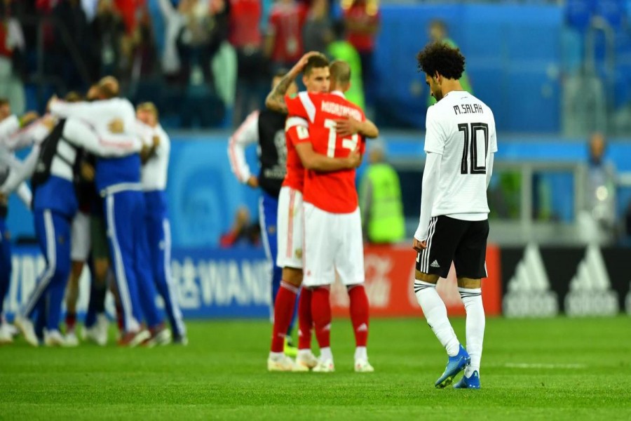 Egypt’s Mohamed Salah makes his way off the pitch as two Russia players celebrate at full time. Reuters.