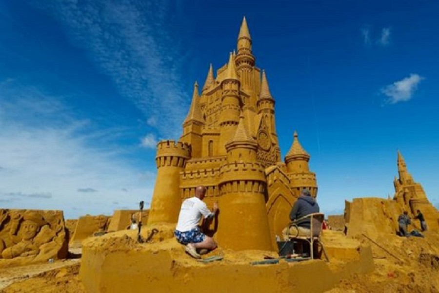 A sand carver works on a sculpture during the Sand Sculpture Festival "Disney Sand Magic" in Ostend, Belgium, June 21, 2018. Reuters