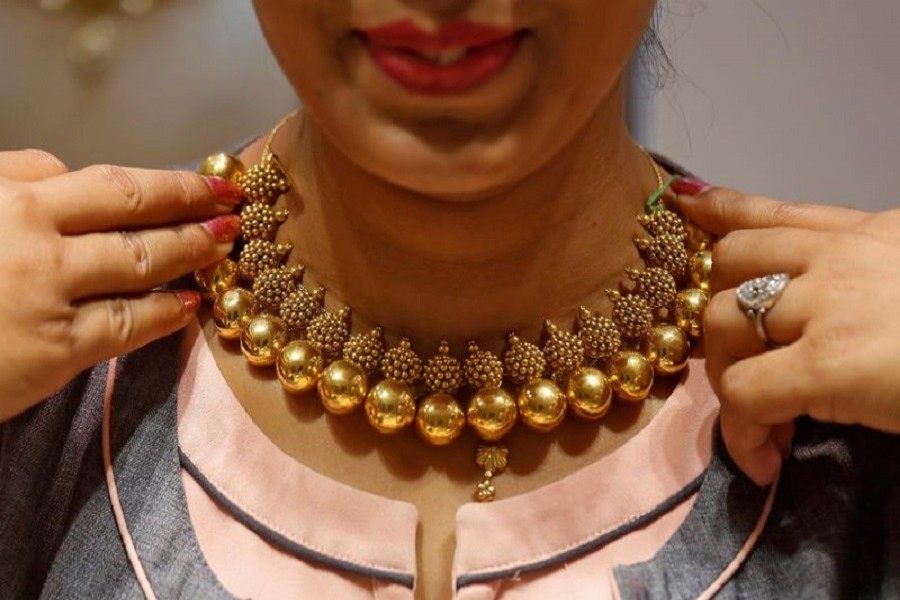 A saleswoman displays a gold necklace to a customer inside a jewellery showroom on the occasion of Akshaya Tritiya, a major gold buying festival, in Mumbai, April 18, 2018. Reuters/Files