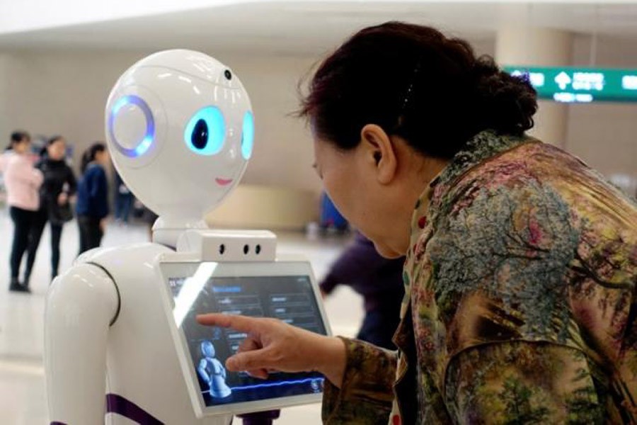 A woman touches a screen on a robot developed by iFlytek at the outpatient hall of People's Liberation Army General Hospital in Beijing, China March 16, 2017. Reuters/File photo