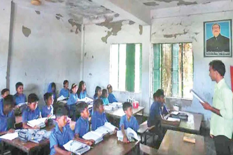 A teacher teaching students in a dilapidated classroom of Choura Government Primary School under Tarash upazila in Sirajganj on Thursday 	— FE Photo