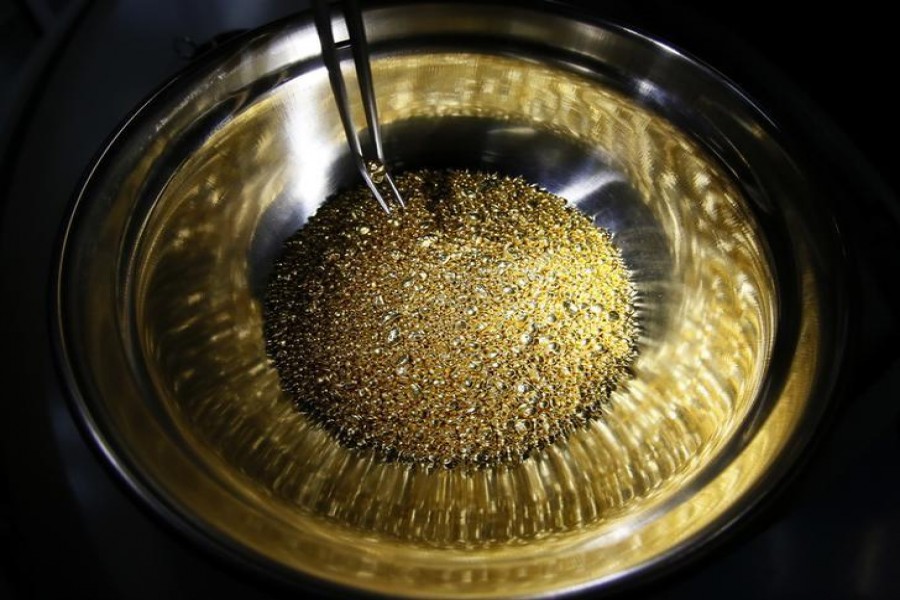 An employee takes granules of 99.99 per cent pure gold, which are used for jewels gilding at the Krastsvetmet non-ferrous metals plant, one of the world's largest producers in the precious metals industry, in the Siberian city of Krasnoyarsk, Russia, December 14, 2016. Reuters/Files